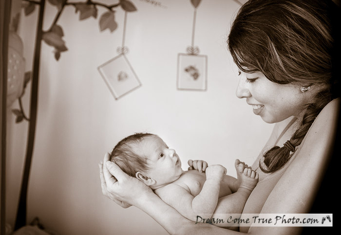 Dream Come True Photo.  Capturing connection: mom just loves her adorable newborn baby boy!  The first photographs in the nurcery