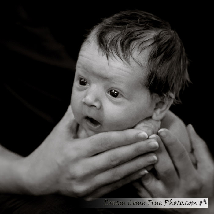 Dream Come True Photo.  The newborn baby is very surprised how he fits into mommy's hands