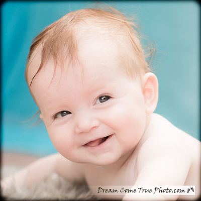 Dream Come True Photo: a wonderful expression of an adorable baby boy is smiling and looking at the camera during our 4 month old session