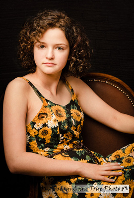 Beautiful senior, teenage girl, sitting in a chair during a family photoshoot in Marlboro NJ